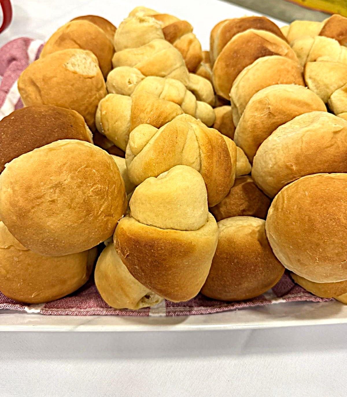Tray of assorted golden-brown bread rolls and buns on a platter