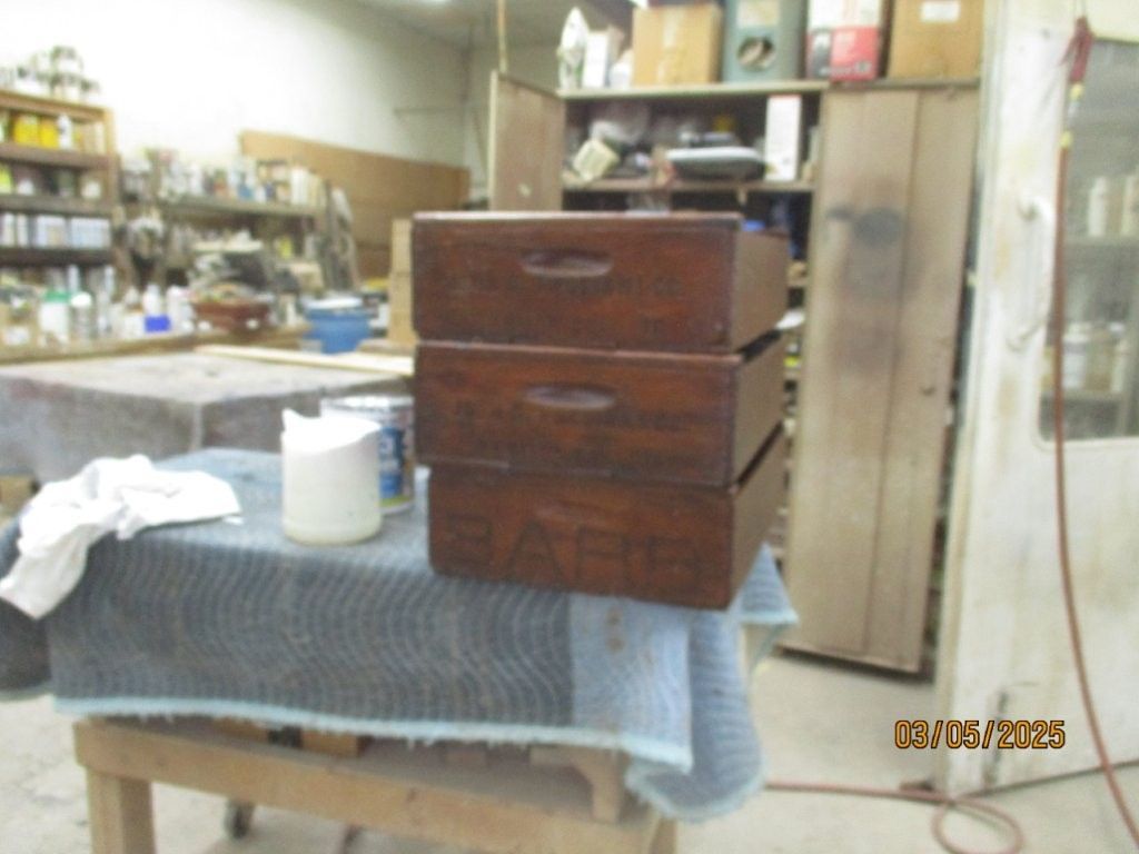 Three wooden drawers are stacked on top of each other on a table.