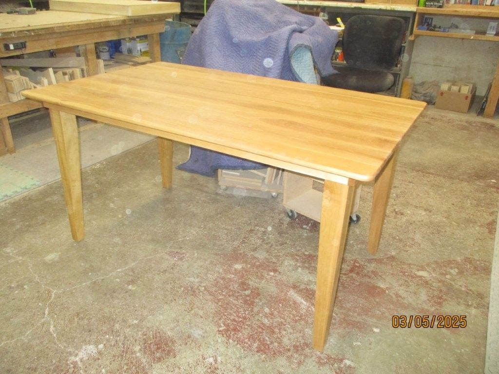 A wooden table next to a blue blanket.