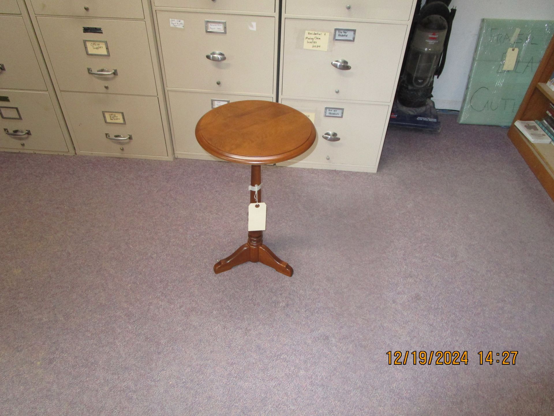 A small wooden table in a room with filing cabinets