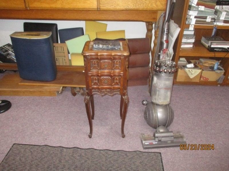 A vacuum cleaner is sitting next to a small table
