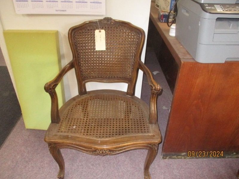 A wicker chair with a tag attached to it