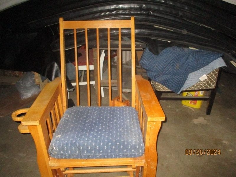 A wooden rocking chair with a blue cushion on it