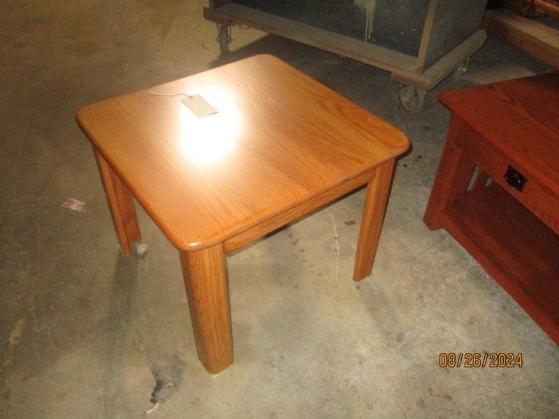 A small wooden table is sitting on a concrete floor