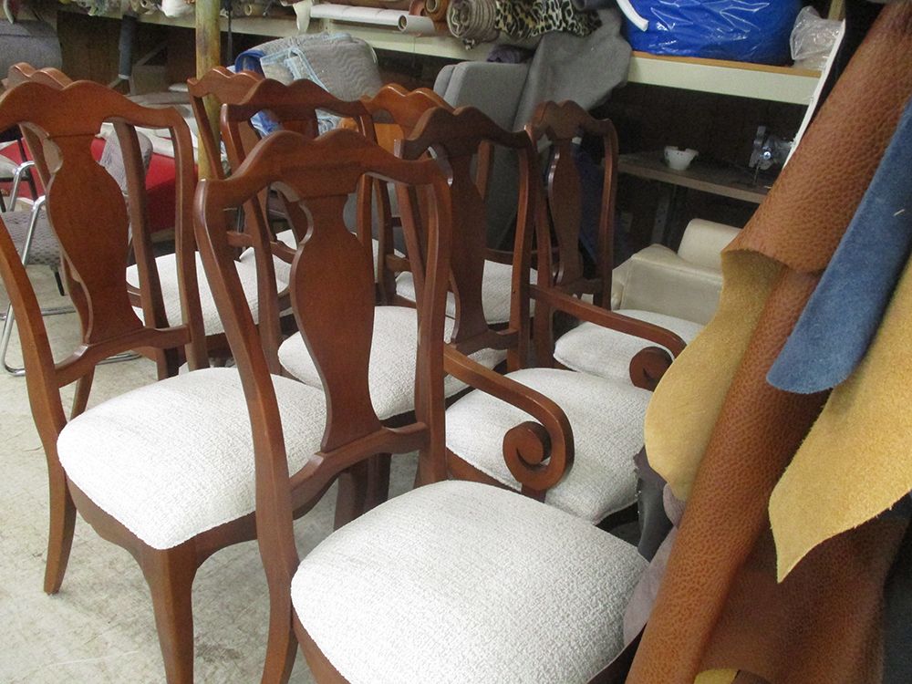 A row of wooden chairs with white seats