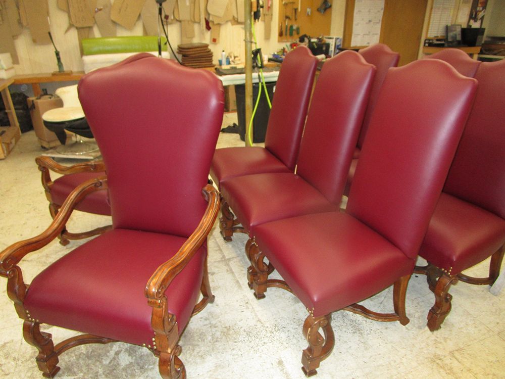A row of red leather chairs are sitting in a room.