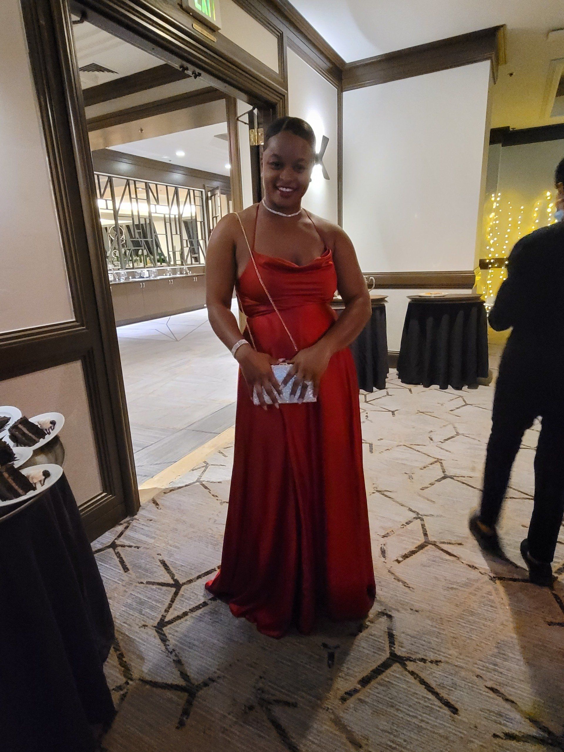 A woman in a red dress is standing in a room.