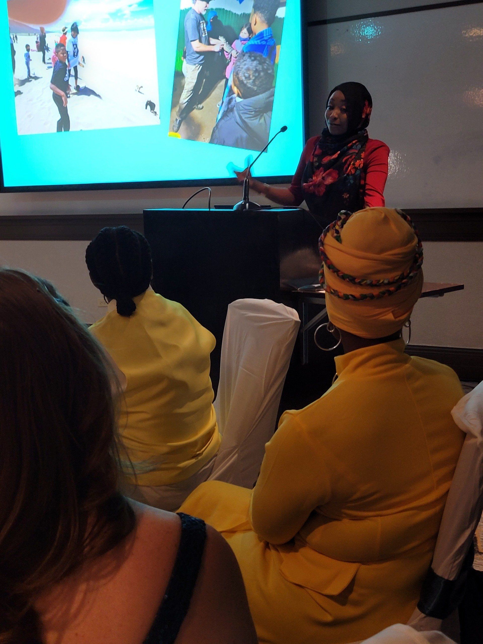 A woman is giving a presentation to a group of people