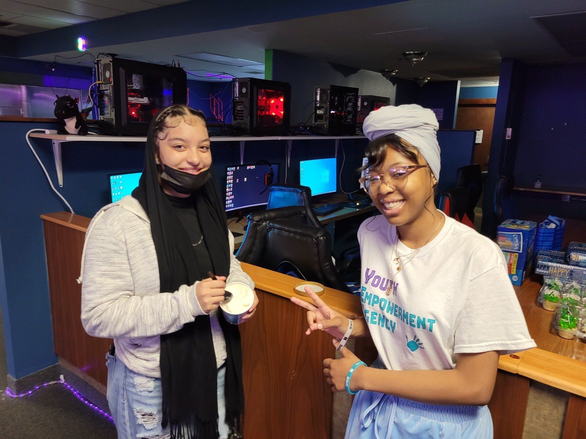 Two young women are standing next to each other in a room.