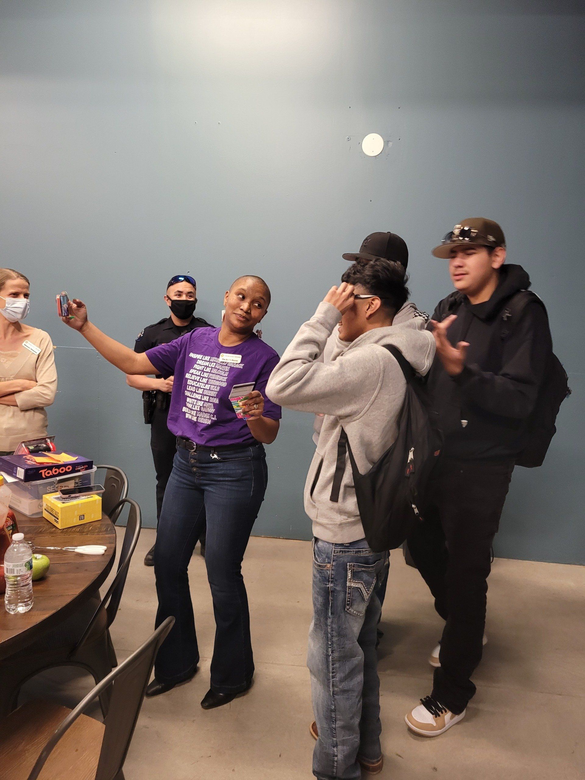 A group of people are standing around a table in a room.