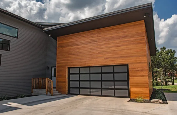 Modern house exterior with wood facade and a black-framed garage door