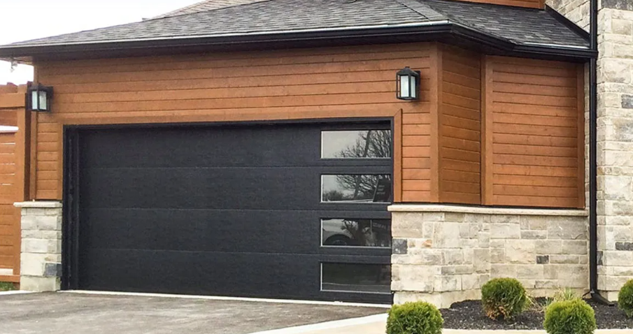 Modern house with a black garage door, wood siding, and stone lower exterior.