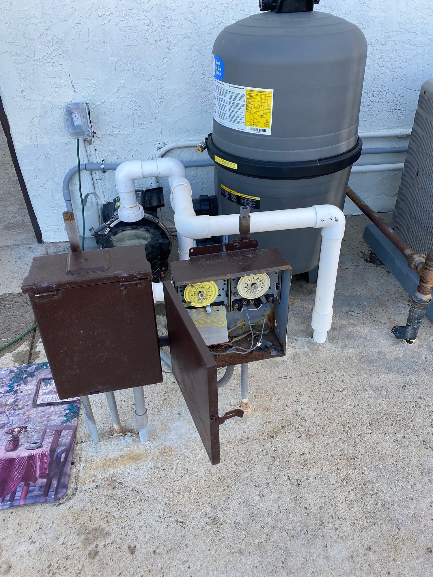 Pool equipment with an open electrical box.