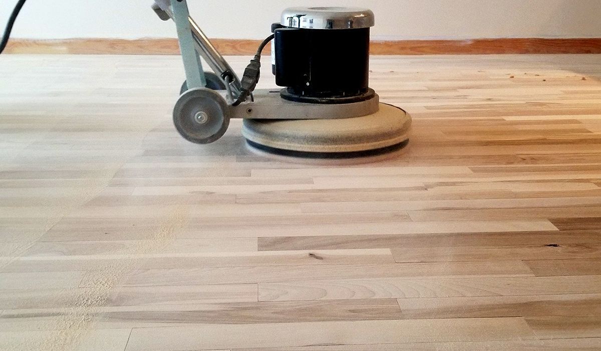 Floor buffer polishing a hardwood floor in a room
