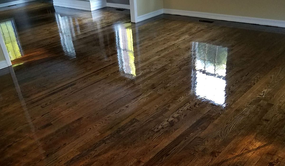 Shiny hardwood floor with bright window reflections in an empty room
