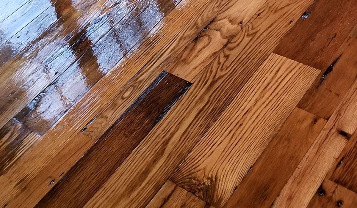 Close-up of glossy hardwood floor planks with wood grain and reflections