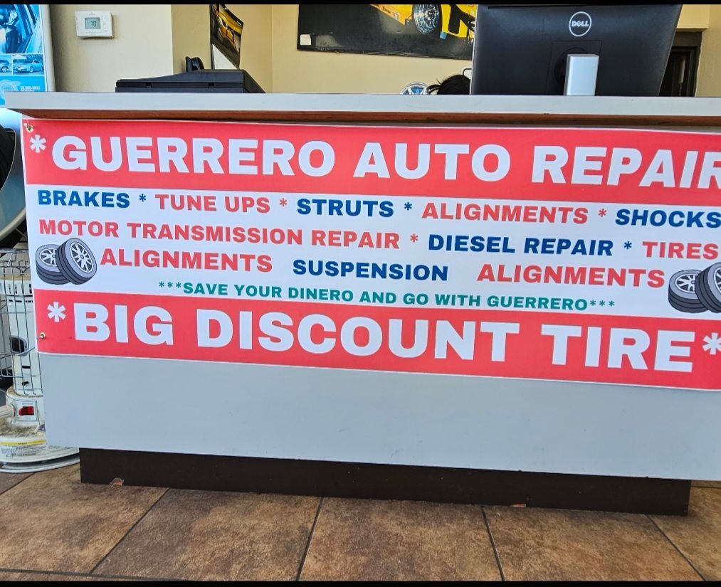 Red and white Guerrero Auto Repair and Big Discount Tire service counter sign in a shop.