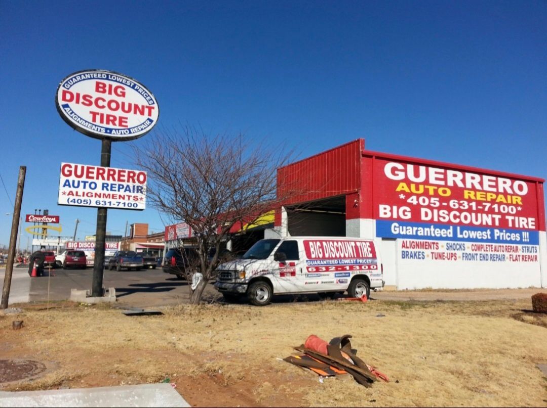 Guerrero Auto Repair and Big Discount Tire lot with red building, signs, and service van.