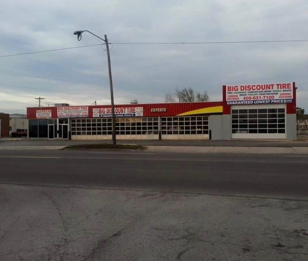 Discount Tire storefront with red signage beside a road on an overcast day.