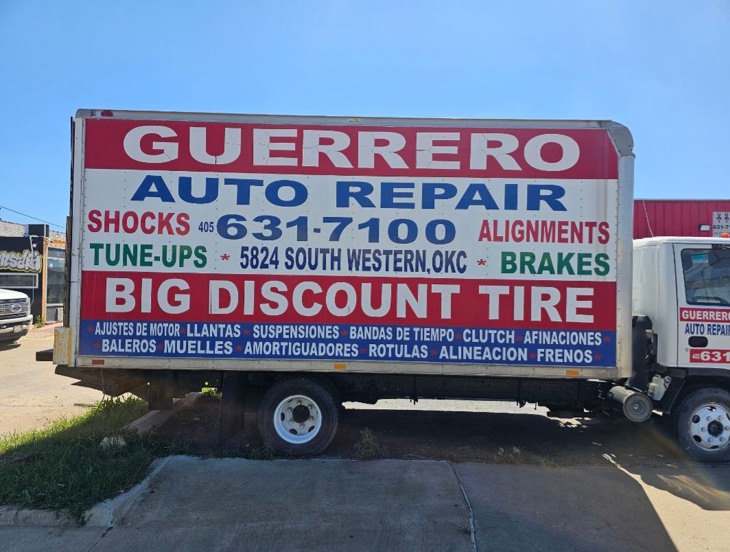 Guerrero Auto Repair trailer with large red, blue and white signage parked outdoors.