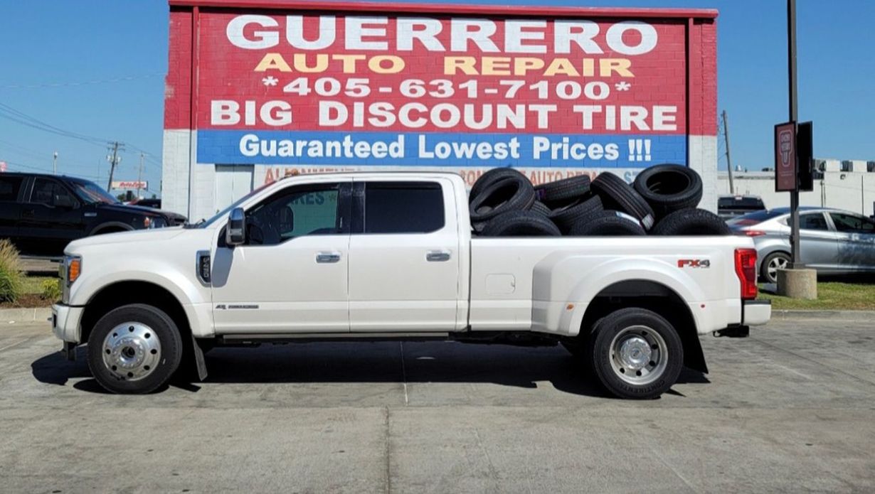 White pickup truck parked in front of Guerrero Auto Repair and Big Discount Tire sign.