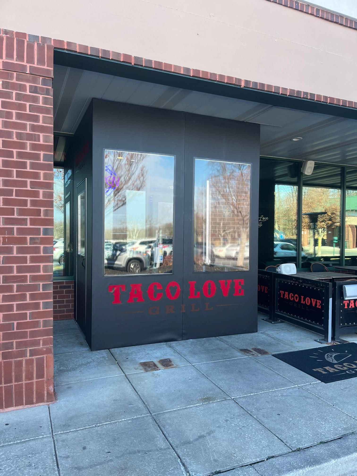Exterior of Taco Love restaurant with a dark gray entrance.