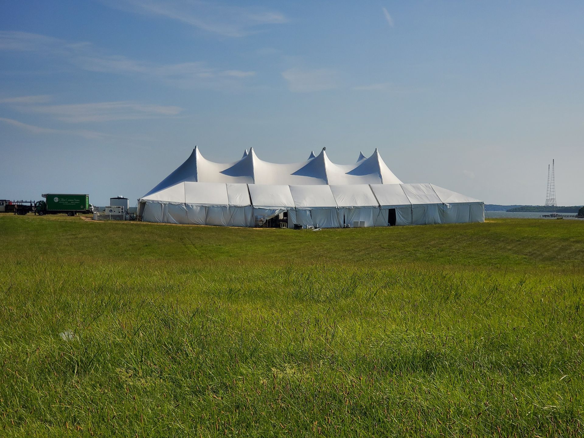 White tent in a grassy field on a sunny day.