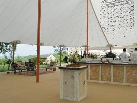 A large white tent with a bar underneath it