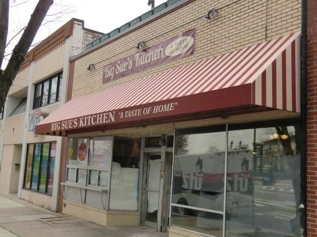 Big Sue's Kitchen restaurant, brick building with red and white striped awning. 