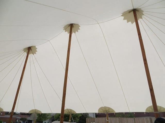 Looking up at the ceiling of a tent with wooden poles