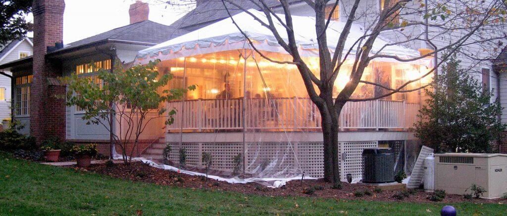 A house with a large porch is lit up at night