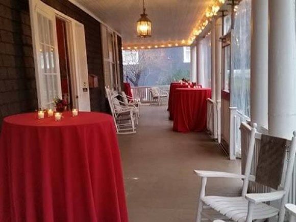 A porch with tables and chairs and candles on them