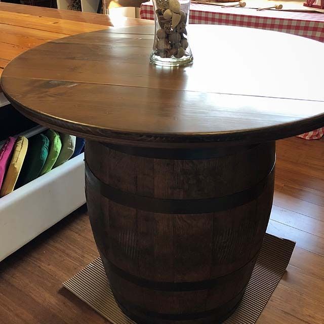 A wooden table with a barrel in the middle of it