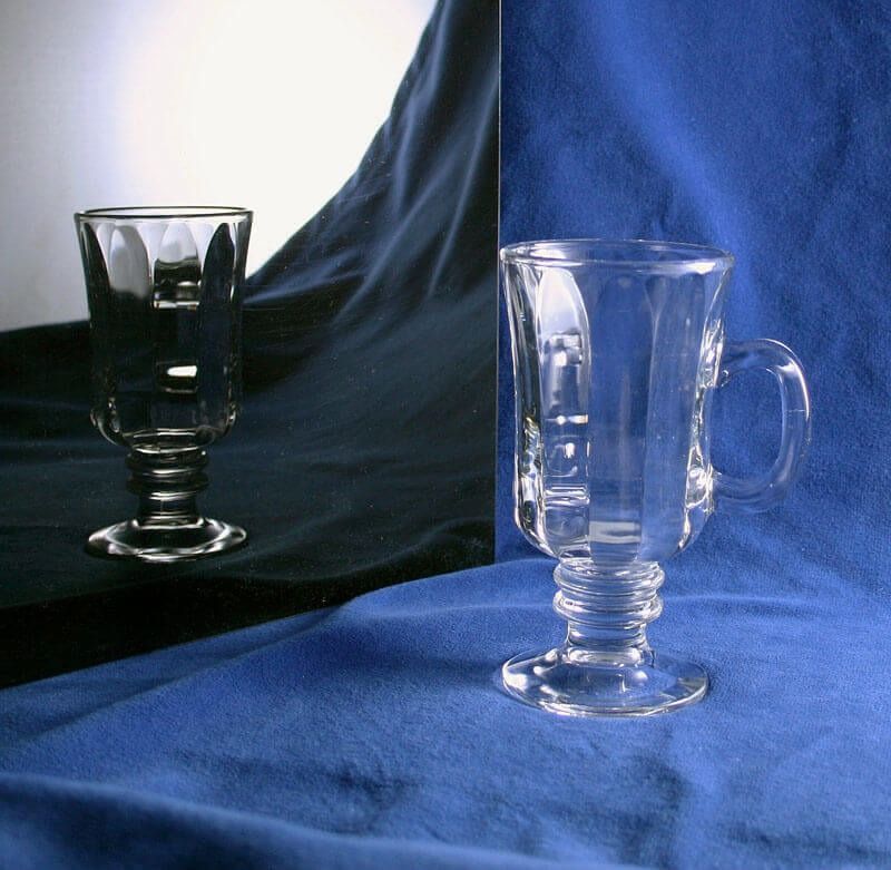 Two wine glasses are sitting on a blue cloth