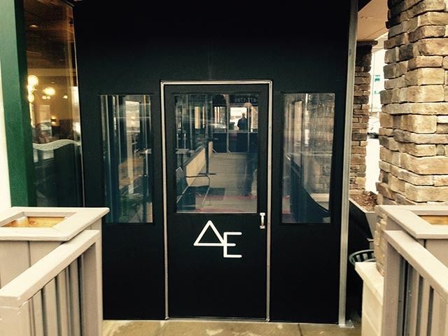 A black door with the letter ae on it