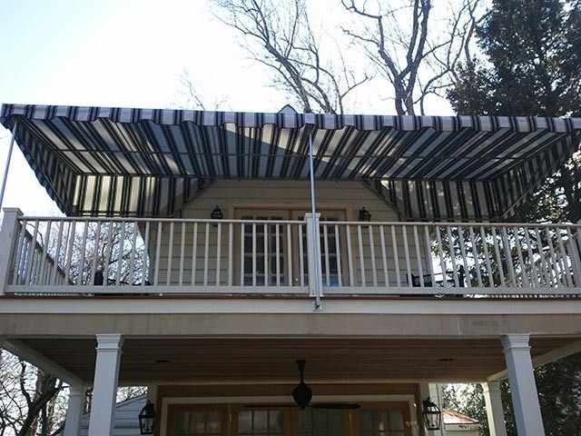 A balcony with a blue and white striped awning over it