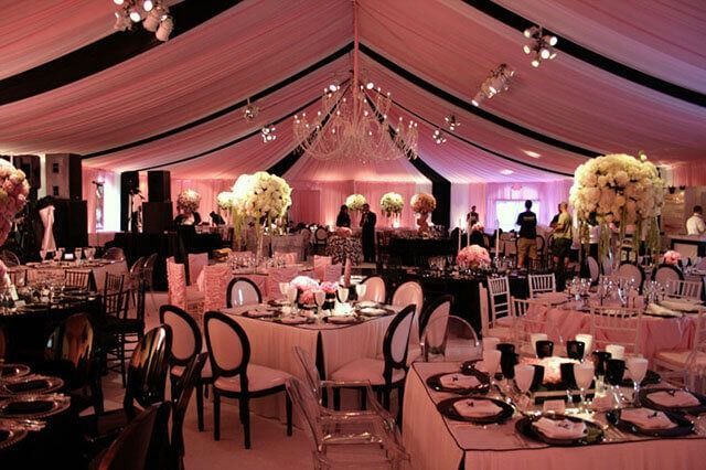A large room with tables and chairs set up for a wedding reception