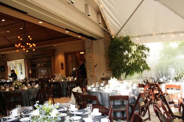 A large room with tables and chairs set up for a wedding reception