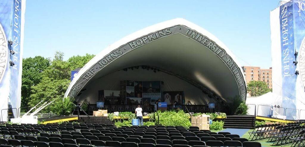 A large stage with a few rows of chairs underneath it