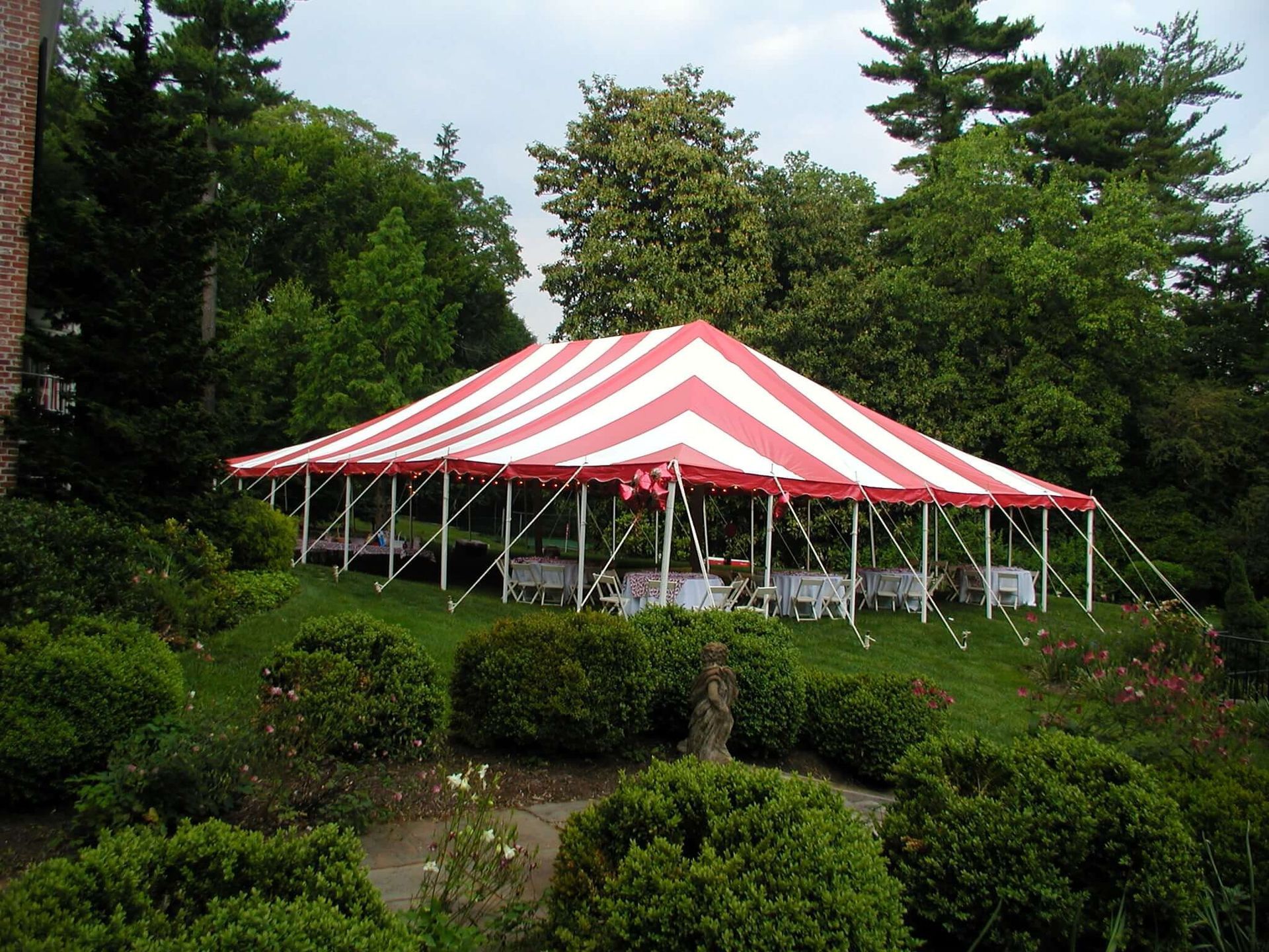 A red and white striped tent with tables underneath it