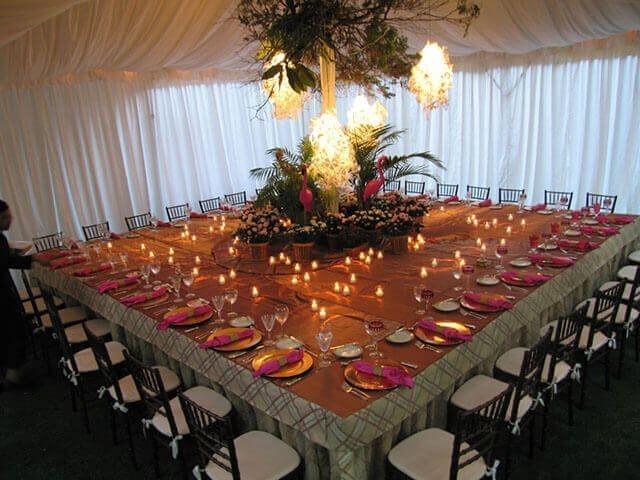 A long table with plates and candles on it