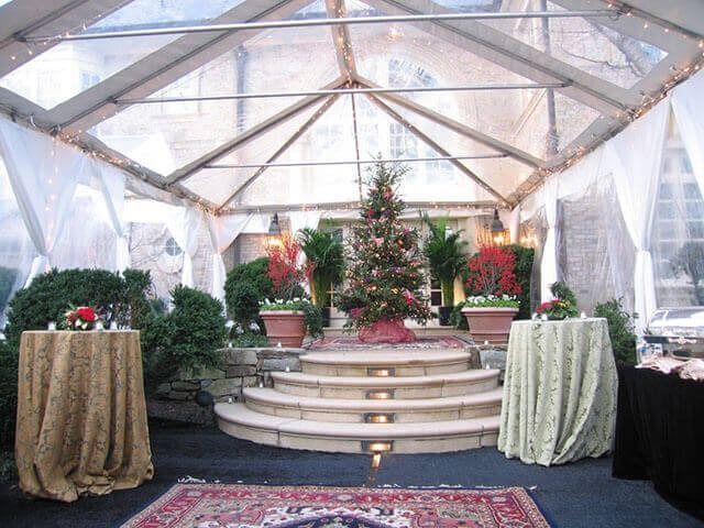 A clear tent with tables and a christmas tree in the middle
