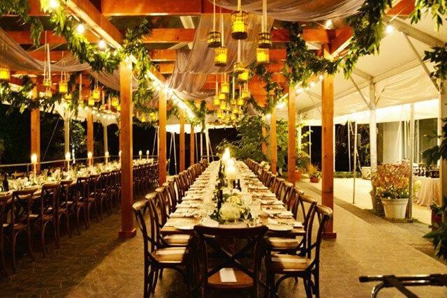 A long table with lots of chairs under a tent