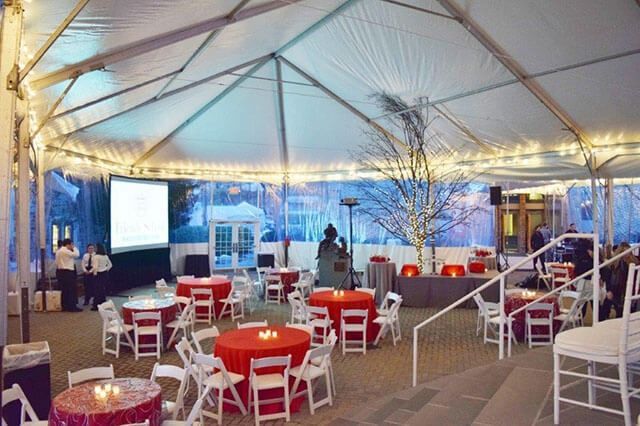 A large tent with tables and chairs underneath it