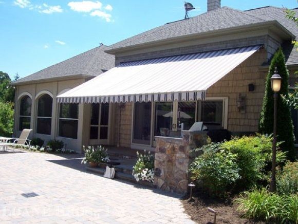 A house with a striped awning on the side of it
