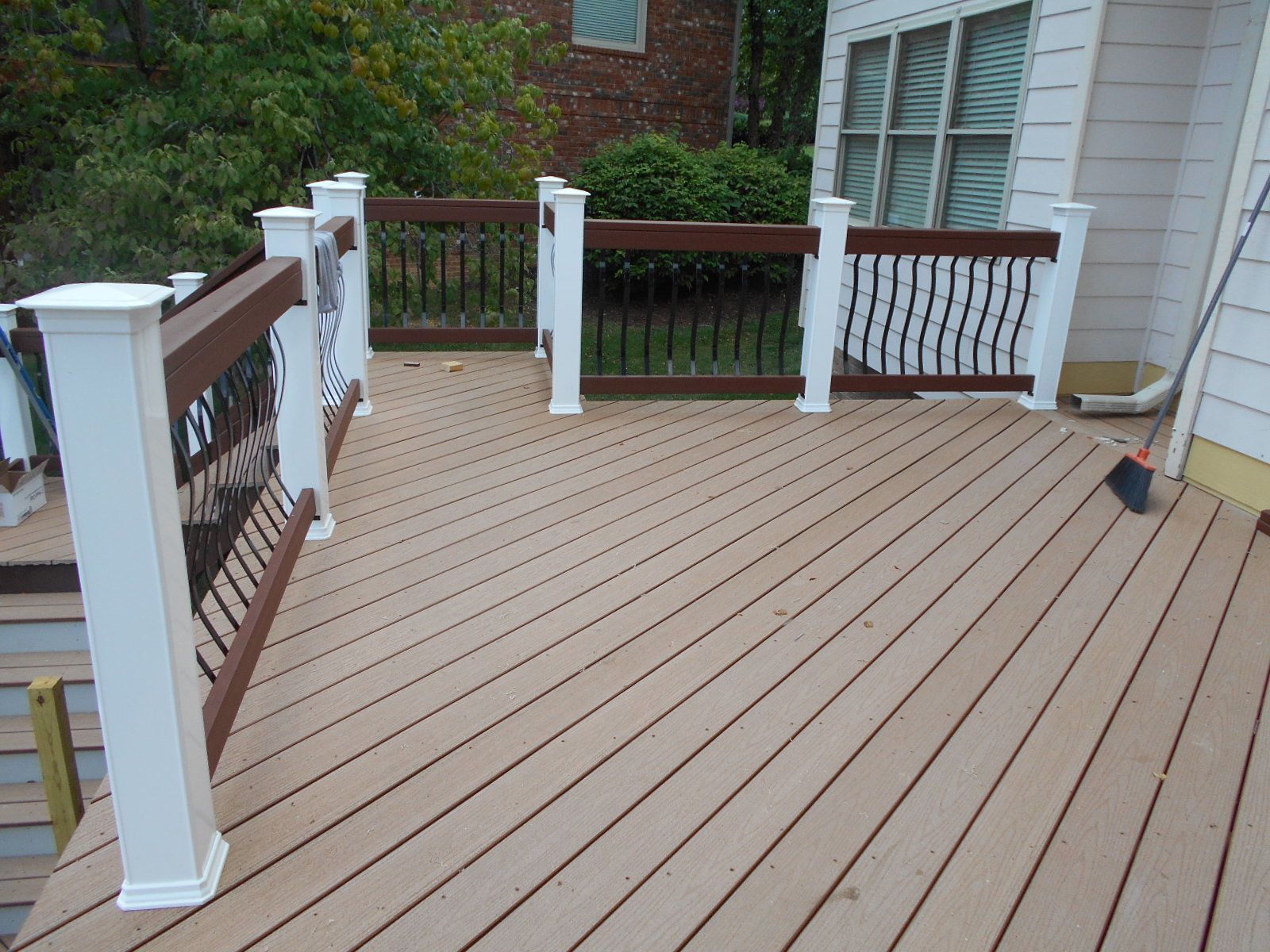 A wooden deck with a white railing and stairs