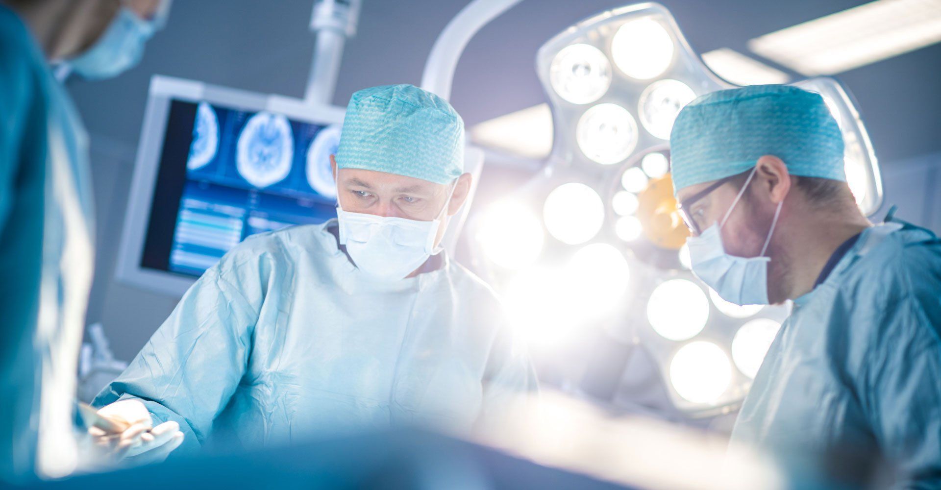 Assistant Hands out Instruments to Surgeons During Operation