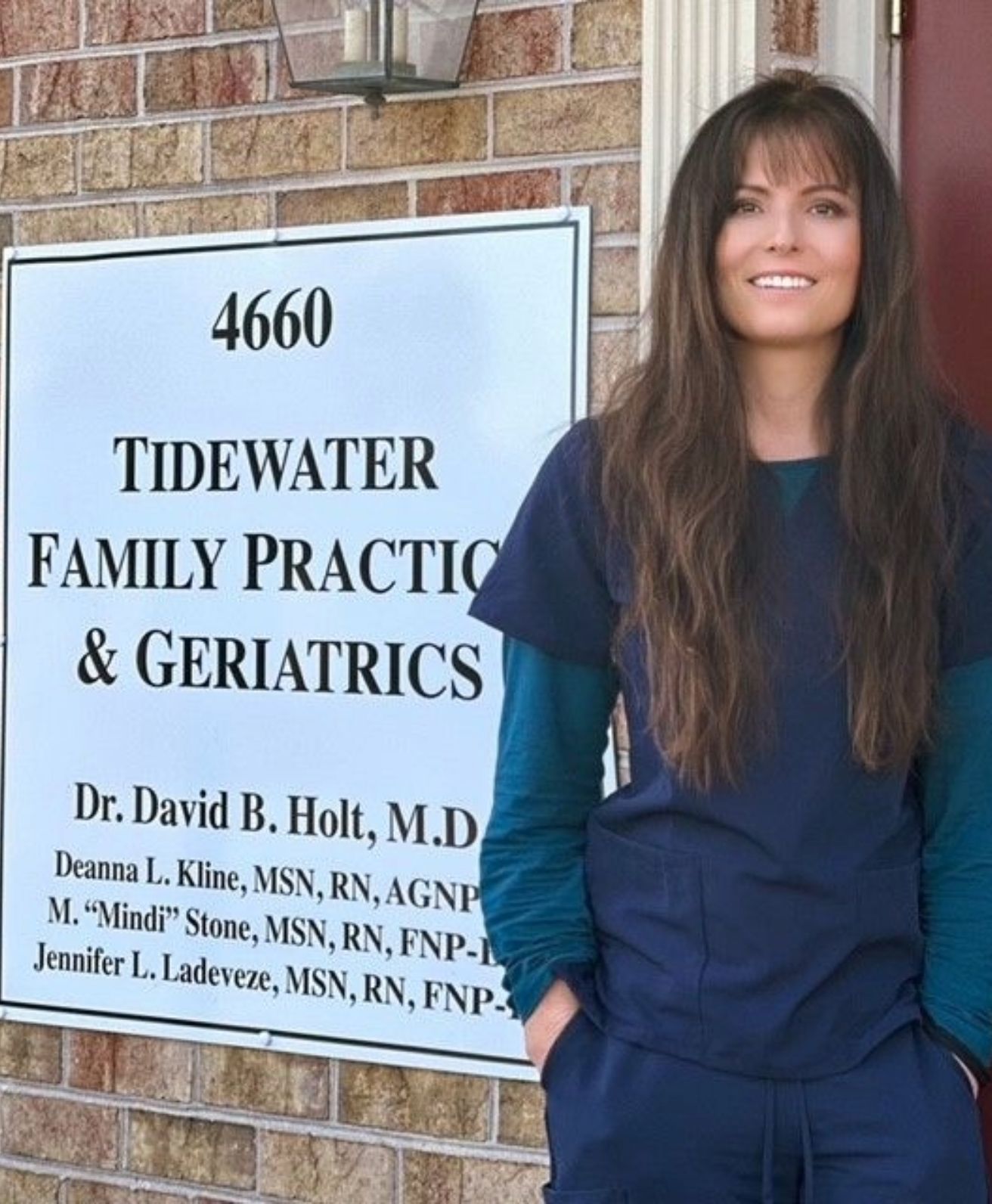 jennifer ladeveze standing in front of a sign that says tidewater family practice & geriatrics