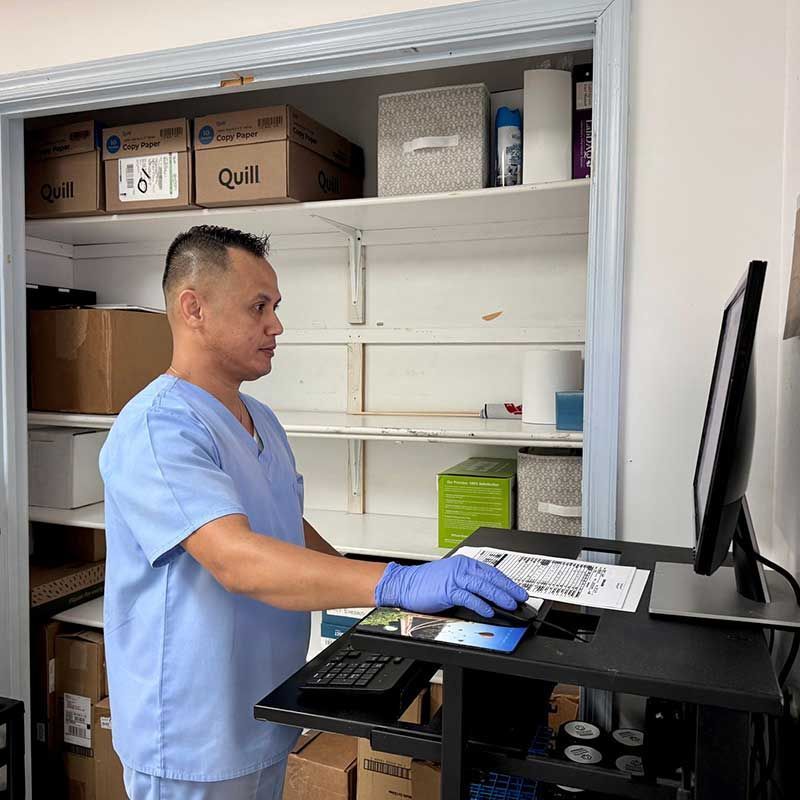 a man in a blue scrub is working on a computer