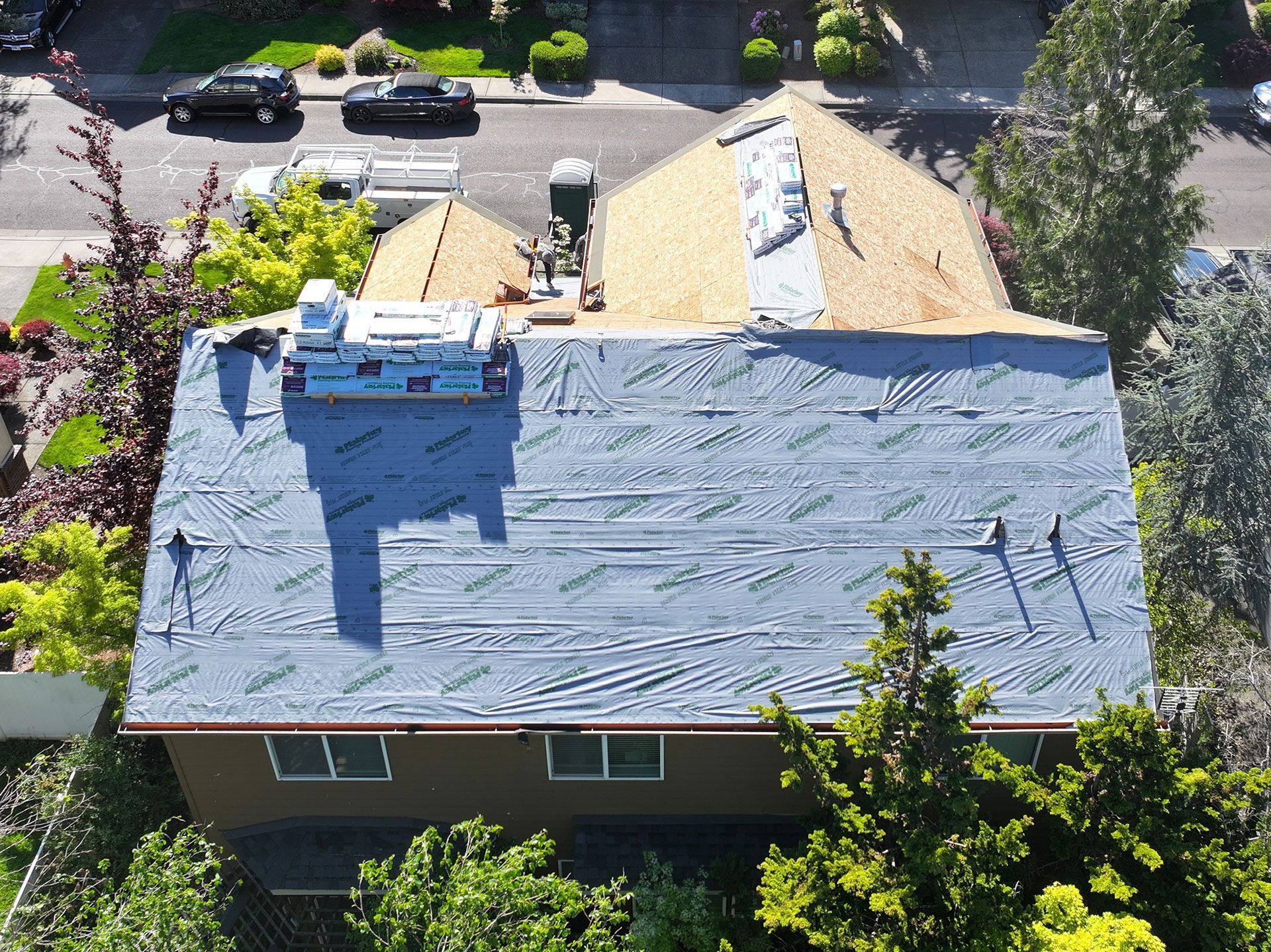 An aerial view of a house with a new roof being installed